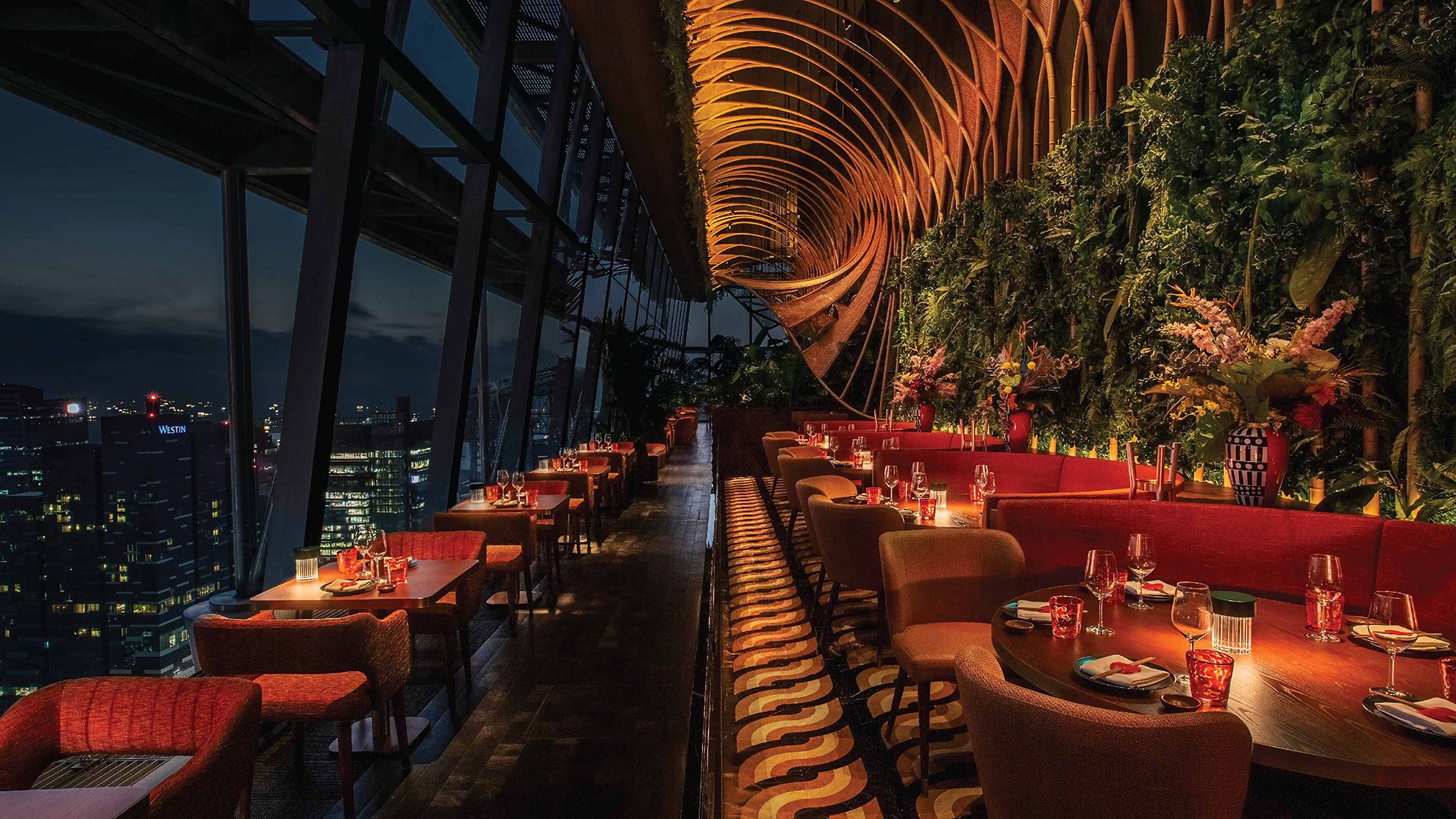 Discover SUSHISAMBA Singapore restaurant on the 52nd floor of Capital Tower, plush orange banquettes set next to dramatic slanted glass windows with panoramic city views.