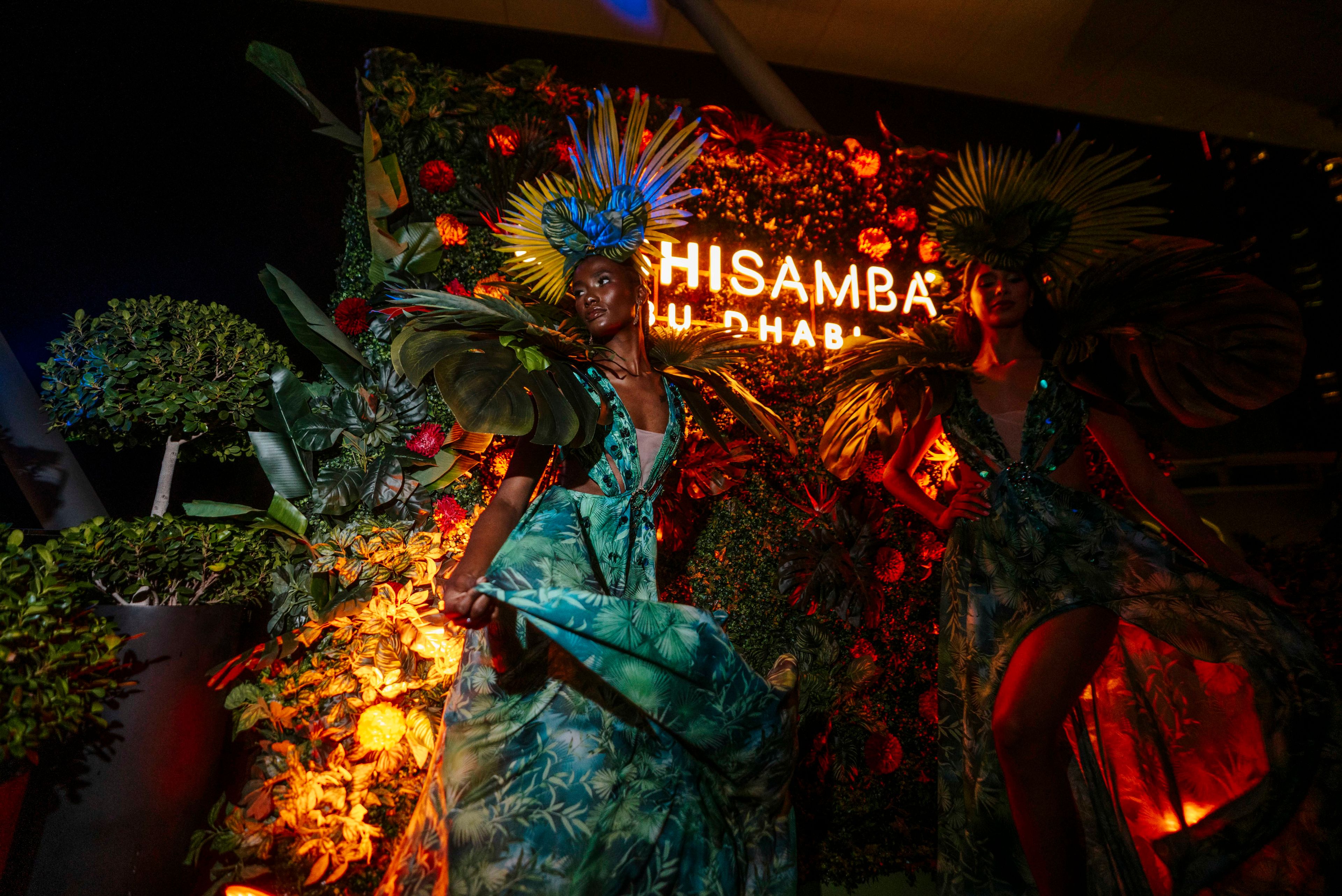 SUSHISAMBA ABU DHABI Celebration with models in costumes in front of neon SUSHISAMBA signage
